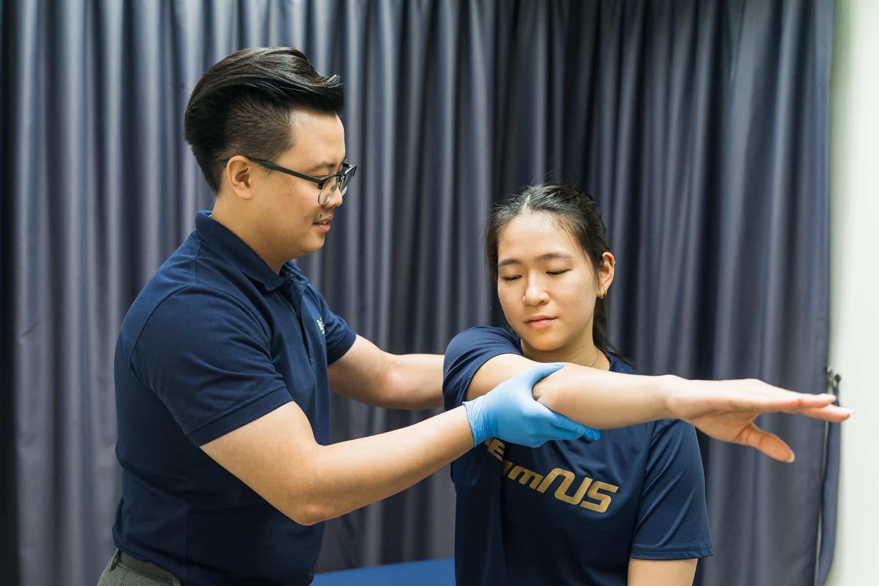 Physiotherapist performing arm and shoulder examination with manual technique and assessment focus. Shows upper limb evaluation, arm palpation, shoulder assessment, and detailed diagnostic therapy. Keywords: arm examination, shoulder therapy, upper limb assessment, manual technique, physical evaluation, clinical assessment.