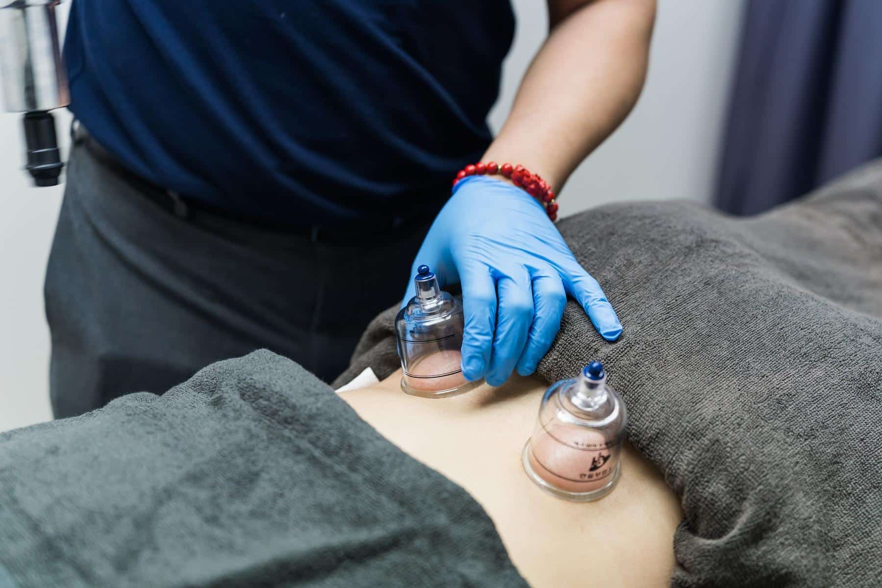 Physiotherapist demonstrating exercise technique or patient assessment in clinical environment. Shows therapeutic instruction, hands-on guidance, treatment demonstration, and professional expertise. Keywords: exercise demonstration, therapeutic instruction, patient guidance, clinical treatment, professional expertise, rehabilitation technique.
